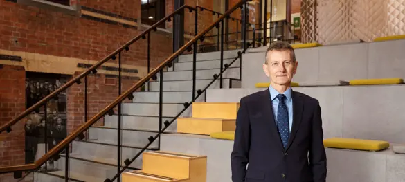 Man wearing a suit standing in front of a stairwell