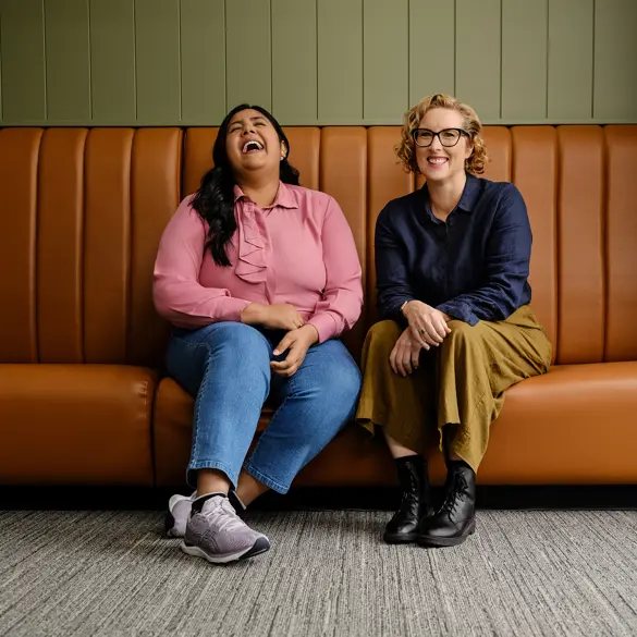 Photo of two happy people sitting on a vintage sofa.