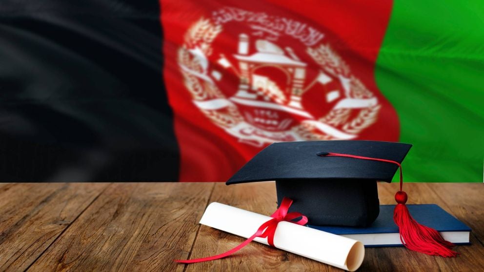 Graduate hat and testamur in front of the flag of Afghanistan