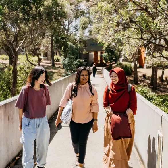 Three students walking along outside