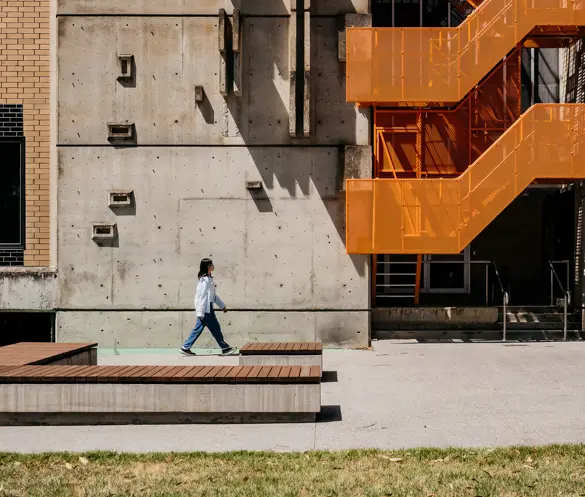 Person walking near modern building on Mt Helen Campus.