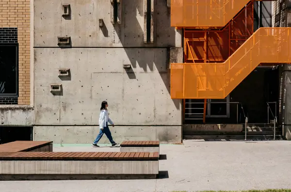 Person walking near modern building on Mt Helen Campus.