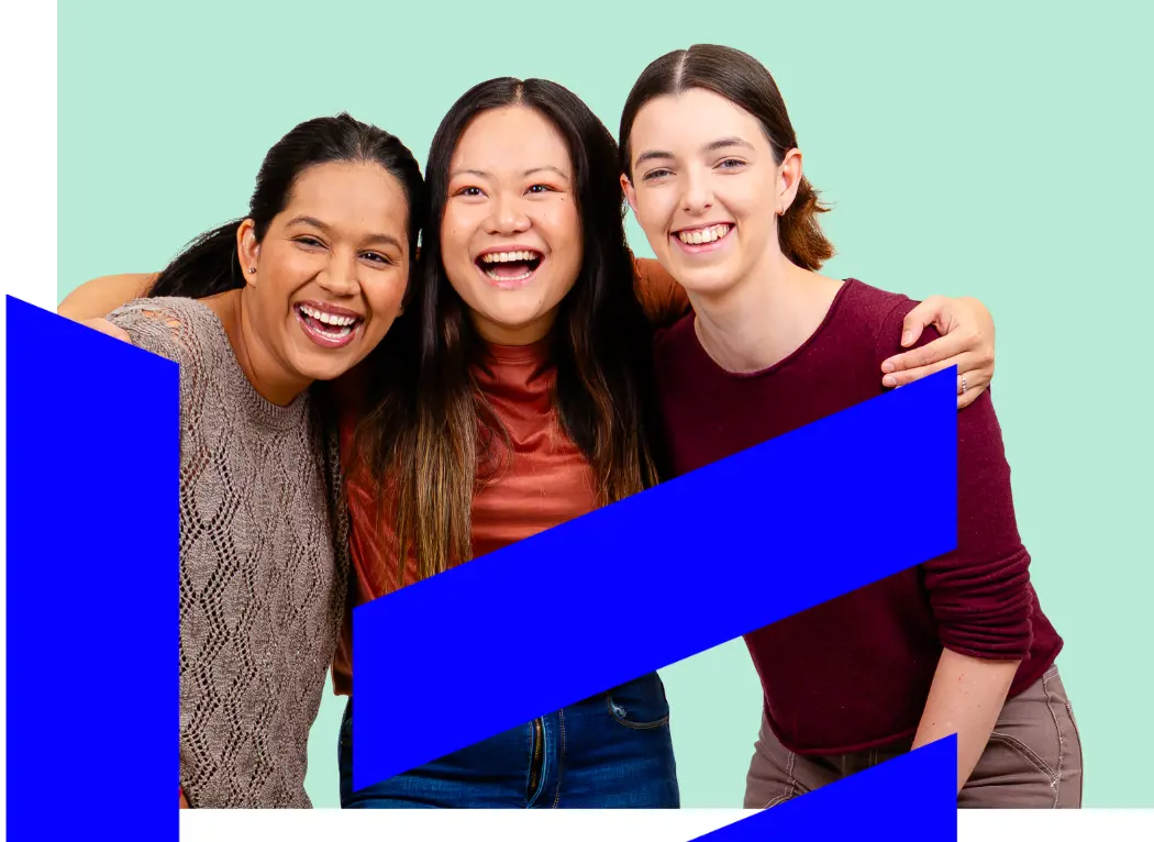 Photo of three women standing close and smiling.
